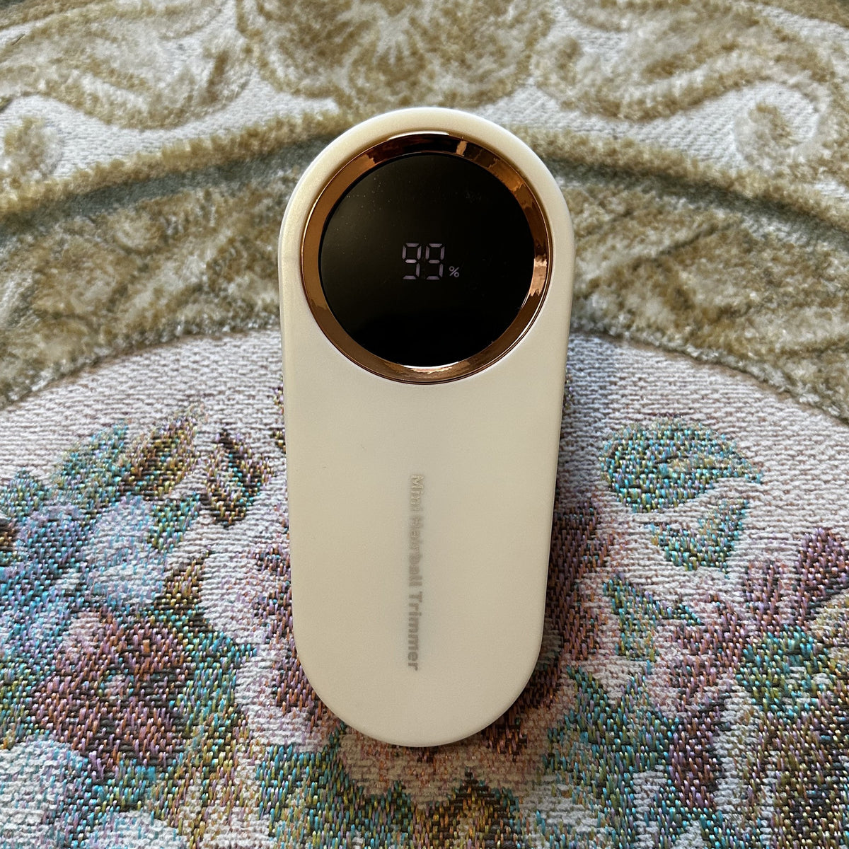 Rasoir anti-bouloches crème Maille Neuve vu de dessus, écran LED allumé indiquant 99 % de batterie